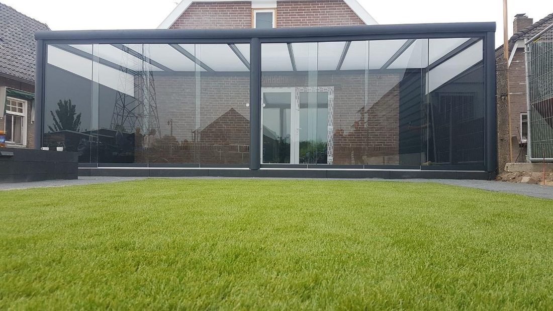 Freistehende Terrassenüberdachung aus Aluminium und Glas im Garten