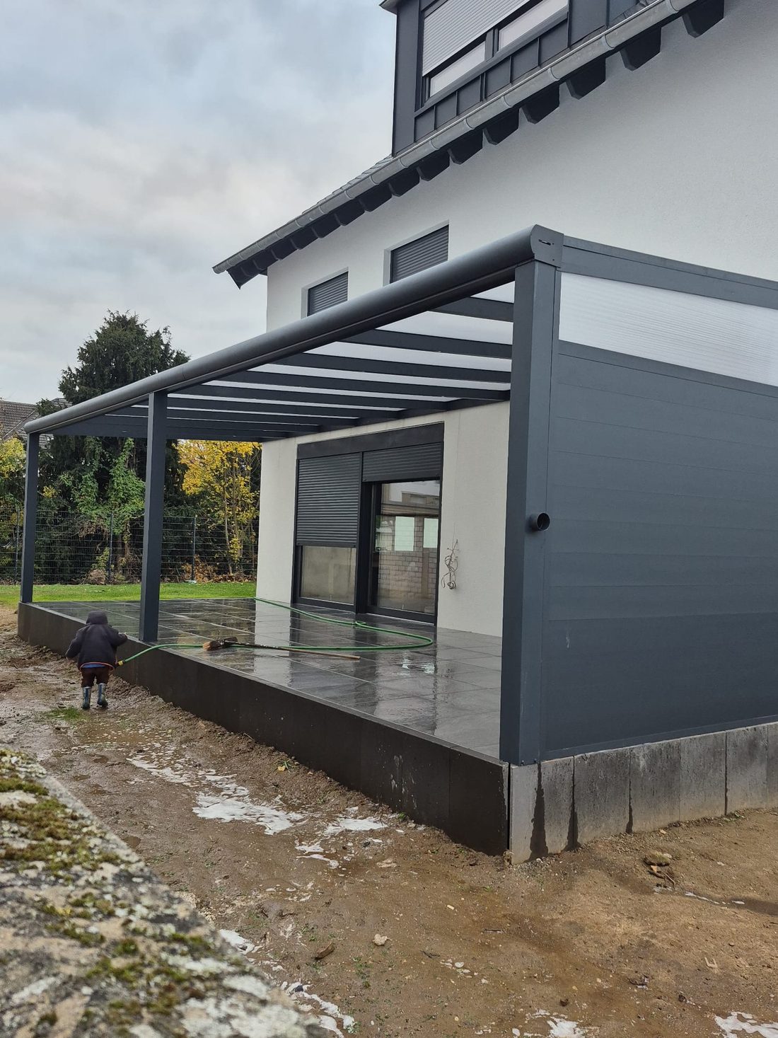 Anthrazitfarbenes Terrassendach an einem Einfamilienhaus
