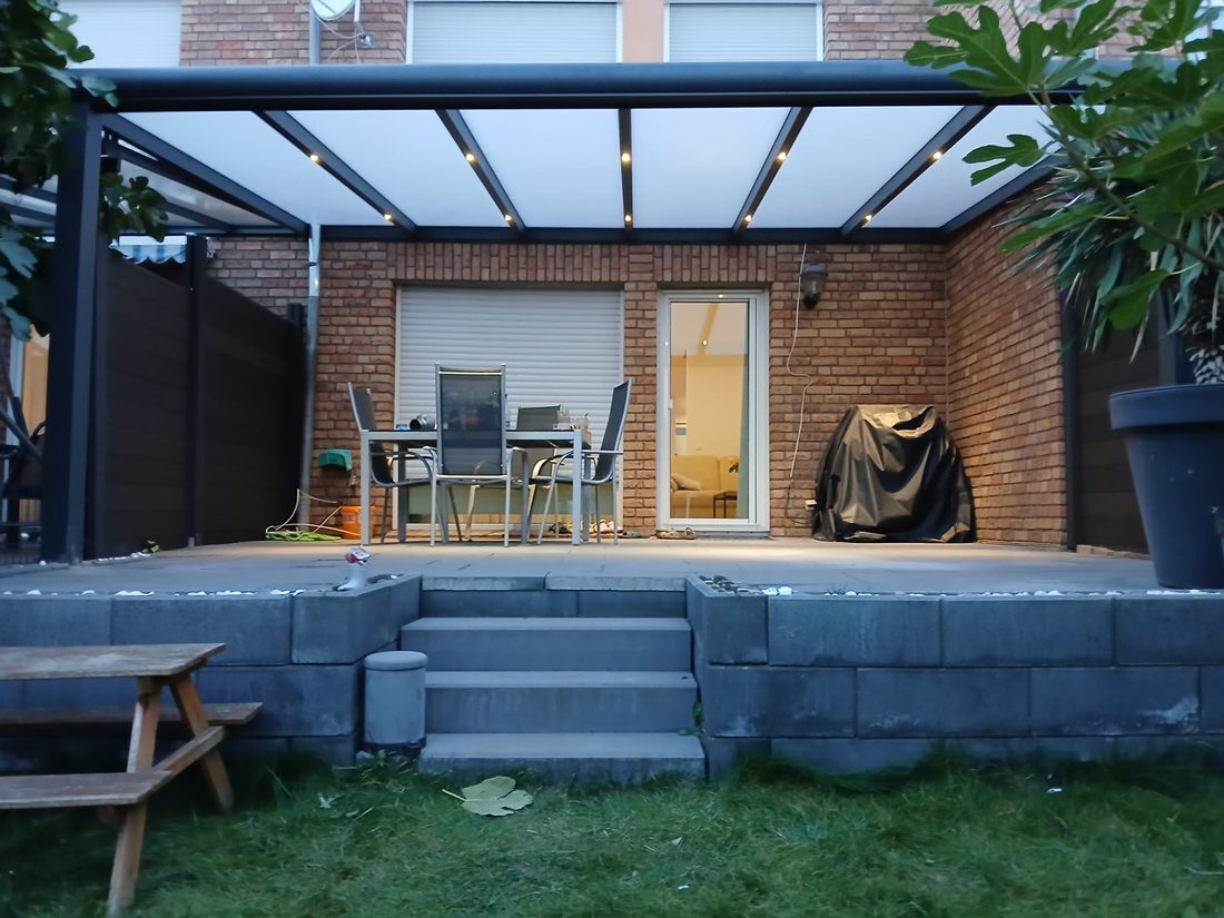 Freistehende Terrassenüberdachung auf einer gepflasterten Terrasse