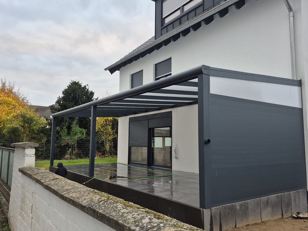 Anthrazitfarbene Terrassenüberdachung an einem Einfamilienhaus