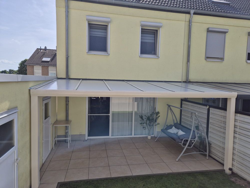Terrassenüberdachung an einem Wohnhaus mit Garten
