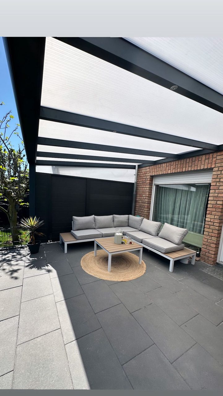 Terrassendach mit weißer Dacheindeckung über einer modernen Garten-Lounge