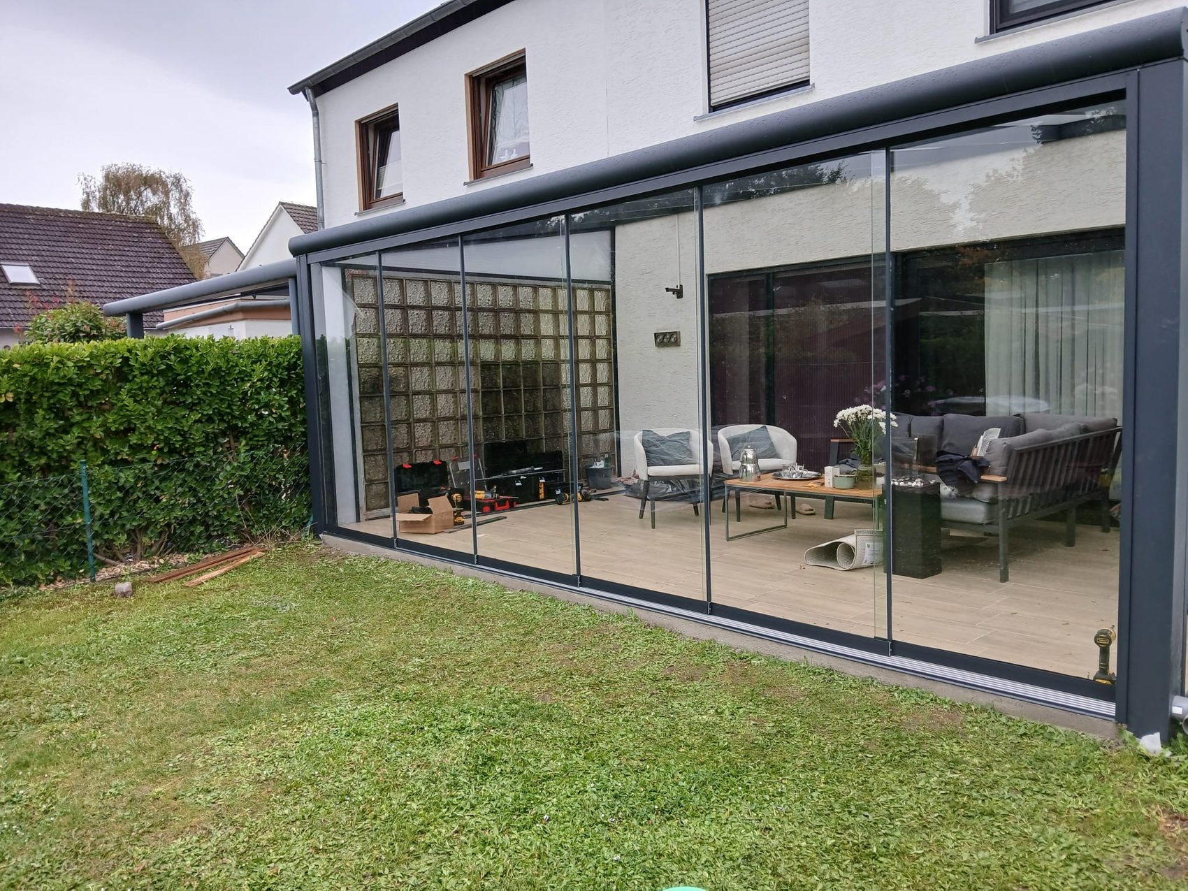 Moderne Terrassenüberdachung aus Glas und Aluminium an einem Einfamilienhaus in der Eifel